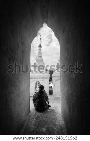 Mandalay, Myanmar - January 16, 2015 .Silhouette figure of women sitting on the arch corridor of Hsinbyume Myatheindan Pagoda White Temple in Mingun, near Mandalay in Myanmar (Burma) Black and white.