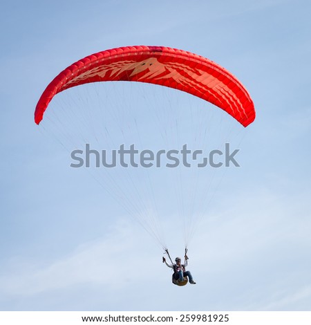 Phuket, Thailand - October 6, 2014 : Paraglider flying in a clear sky on Phuket Island, Thailand. Phuket is a very famous Island in Thailand