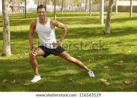 sport man stretching at the park - fitness concepts / Young man sports exercises.