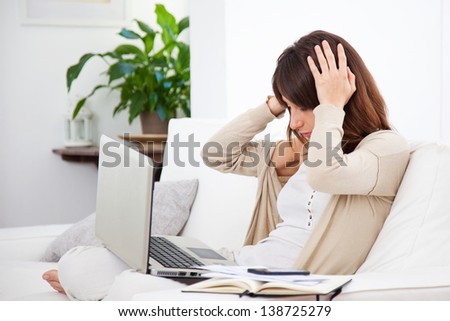Young stressed woman working at home. Woman with hands on head. Stress