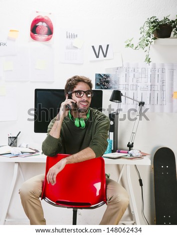 Young creative designer man at phone working at office. / Creative man.