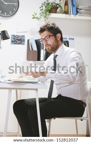 Young businessman working in office. Businessman with rimmed glasses.