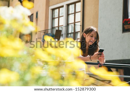 Beautiful woman sending text message with mobile phone. Cute girl sending sms with smart phone.