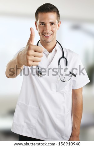 Portrait of smiling medical doctor in the hospital./ Young medical doctor man with stethoscope doing OK.