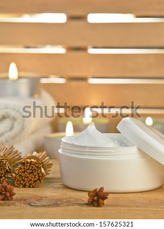 Close up of cream spa product./ Fresh aloe vera slices on wooden with some candles.