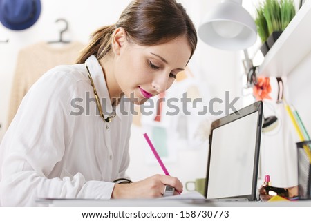 Young woman doing fashion sketches. / Fashion woman blogger working in a creative workspace.