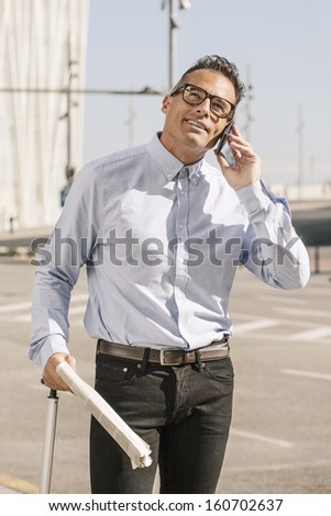 Handsome man in the middle of the street./Businessman talking with smart phone on the city.