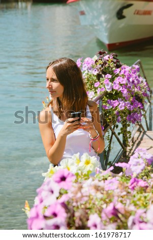 Young woman sending a message in vacations/ Sea background.