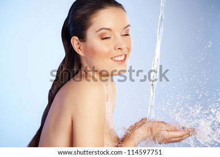 Portrait of young sensuality beautiful woman under the stream of water - blue background
