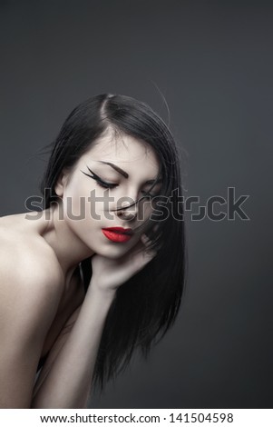 Pretty brunette woman with long straight hair on dark background