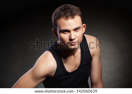 Closeup portrait of a sexy male model on dark grey background