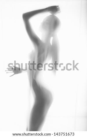 The body of a beautiful naked woman through the transparent fabric on a light background