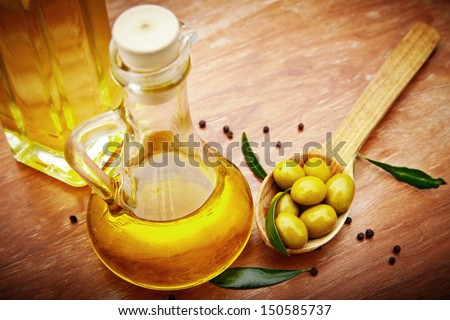 Extra virgin healthy Olive oil with fresh olives on rustic wooden background