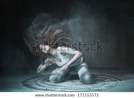 Emotional sexy Wild Woman with Flying hair and ashes in jeans over dark background