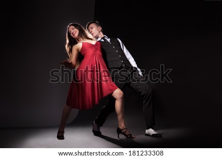 Man and woman in the most romantic dance tango over dark background