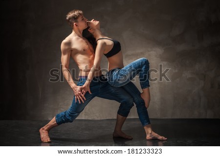 Modern style Man and woman in passionate dance pose over gray back