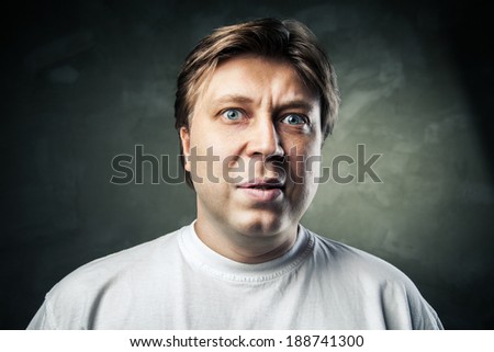 portrait of young beautiful man surprised face expression over gray