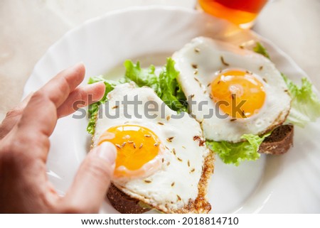 Similar – Image, Stock Photo Anonymous person eating toast with eggs and cheese