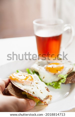 Similar – Image, Stock Photo Anonymous person eating toast with eggs and cheese