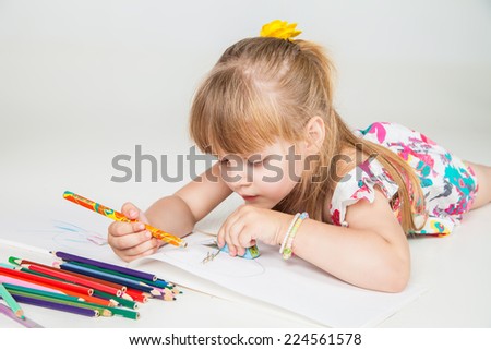 Portrait of lovely girl drawing with colorful pencils