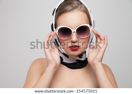 young stylish caucasian woman posing in sunglasses and scarf on head, isolated over white, retro styling