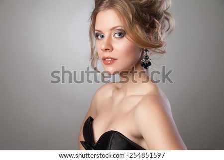 Closeup of beautiful woman with evening make-up and big black earrings looking in the camera. Jewelry and Beauty. Fashion photo