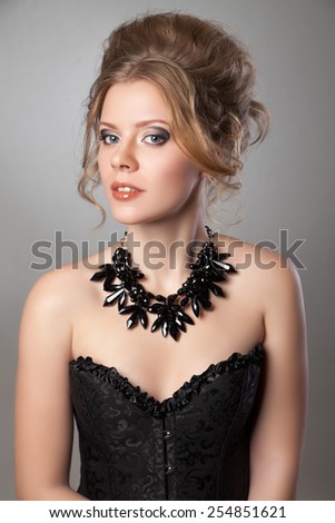 Closeup of beautiful woman with evening make-up and big black necklace. looking in the camera Jewelry and Beauty.
