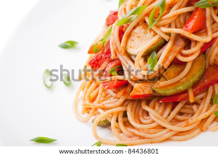 Colorful spaghetti with zucchini and tomato and grated cheese