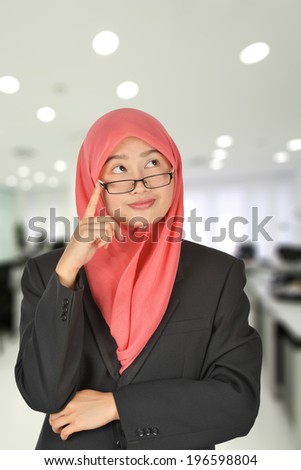 young Muslim woman in head scarf are thinking success, office bokeh background