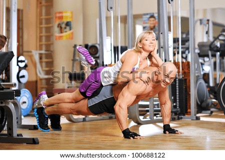 Instructor is doing push-ups with his female co-worker behind the back