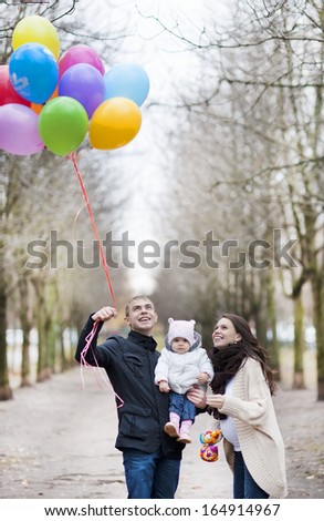Happy family holding bunch of colorful balloons