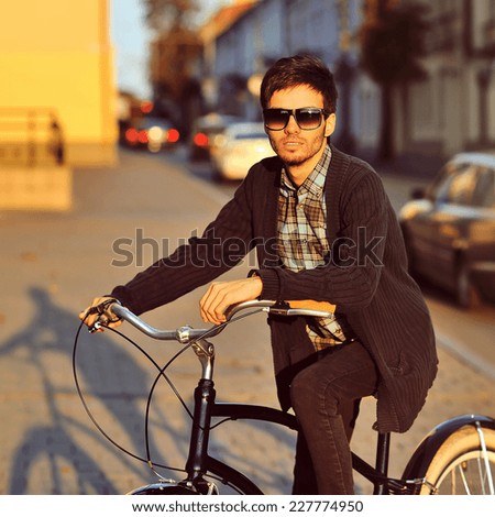 Handsome young man model biking in the city