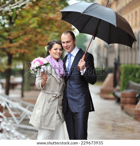 Wedding couple on their wedding day by the rain