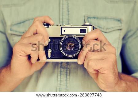Close up portrait of man\'s hands holding vintage camera