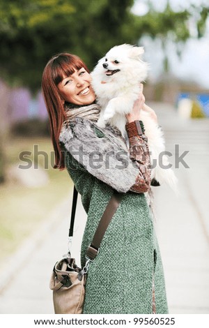 Portrait of a young happy female hugging a cute puppy