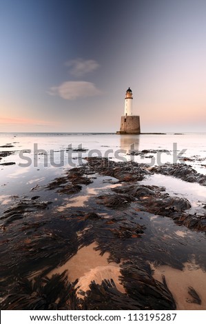 Rattray head lighthouse on the north east coast of Scotland as the Sun setting with the tide coming in.