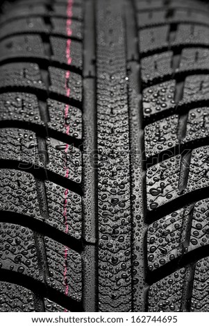 Car tires close-up Winter wheel profile structure with waterdrops
