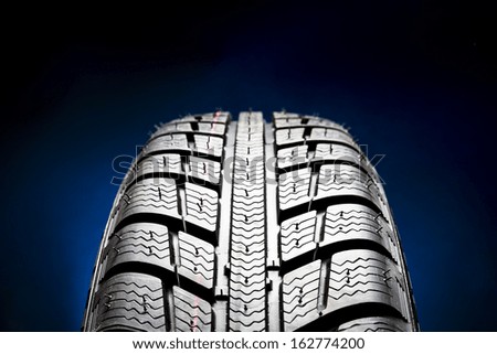 Winter Car tires close-up wheel profile structure on black blue background