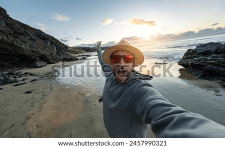 Foto Bild Tourist mit Strohhut in Rückansicht fotografiert in der Bretagne am Meer zwischen Felsen ein Segelschiff