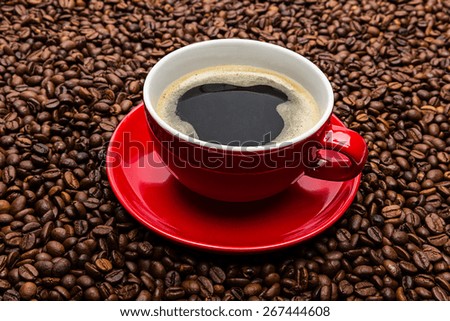 red cup of hot coffee with a brown beans background