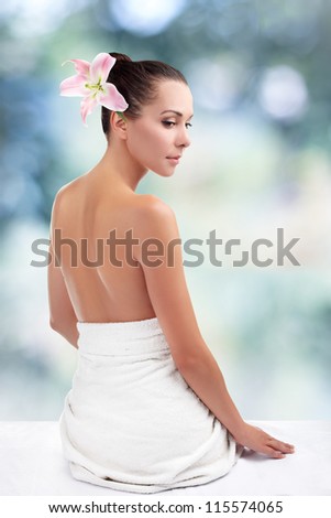 Woman from behind, naked body, against abstract blue background