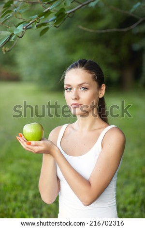 portrait pretty  long-haired woman hands yellow apple background summer park
