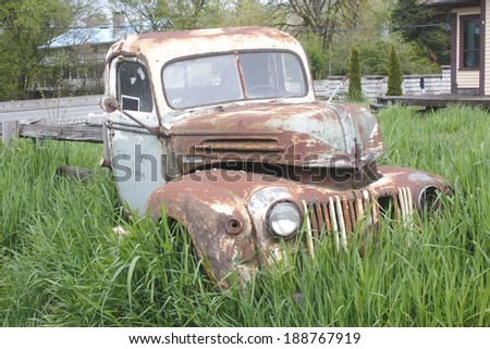 A vintage antique truck sits abandoned and neglected in the tall grass/Vintage Rusting Truck /A vintage antique truck sits abandoned and neglected in the tall grass