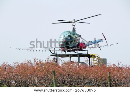SUMAS, WASHINGTON/USA - APRIL 7, 2015: A Crop Duster sits on a small landing pad above a vehicle where it will load chemicals to spray on blueberry crops in Washington State on April 7, 2015.