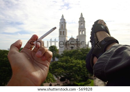 Man relaxing with cigarette overlooking main square of Mexican town