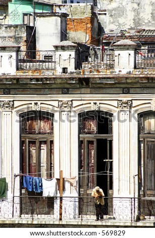 Man on balcony of old crumbling building. Havana, Cuba