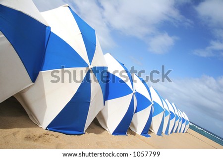 Blue and white parasols on golden beach