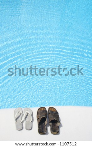 Two pairs of shoes by a bright swimming pool