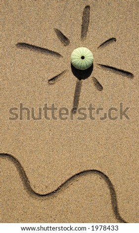 Sun and waves drawn in golden sand on the beach