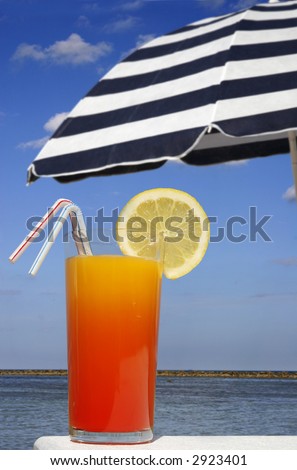 Tropical drink with sunny beach and parasol background